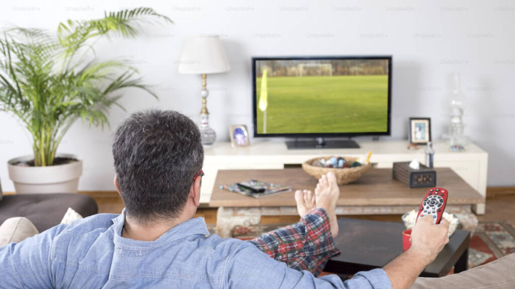 Muž sledující televizi v ideální vzdálenosti od televize
